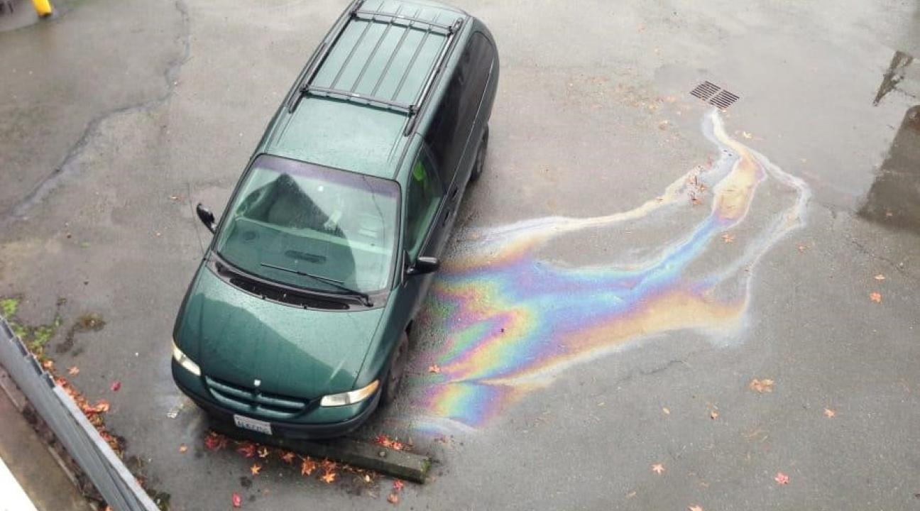 Van leaking oil into a stormwater inlet during a rainstorm