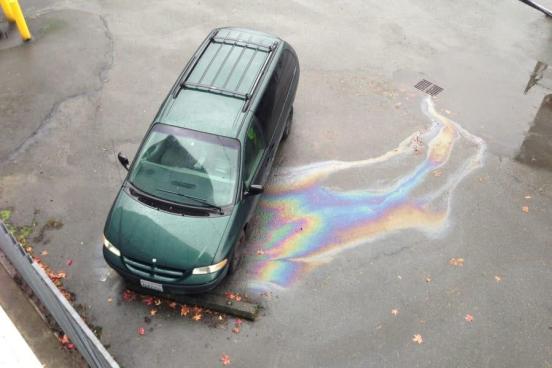 Van leaking oil into a stormwater inlet during a rainstorm